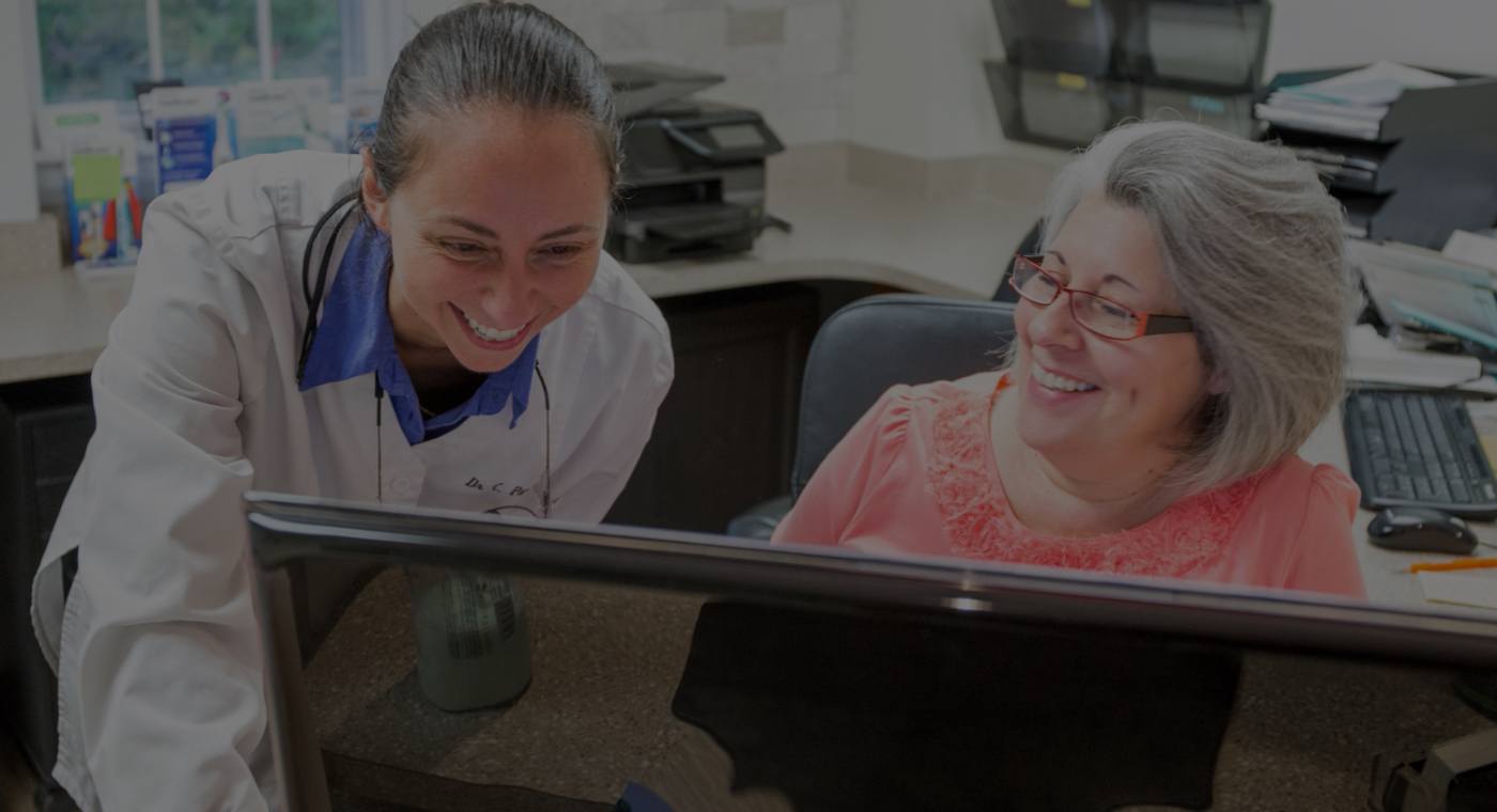 Dental team member and dentist in Natick Massachusetts reviewing patient chart