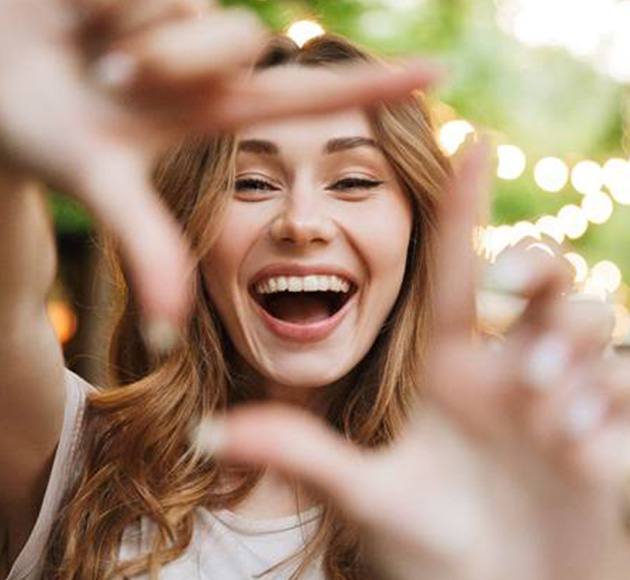 Woman smiling after learning cost of cosmetic dentistry in Natick