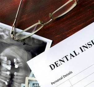 A dental insurance form set on a wooden table