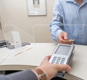 An adult man paying the cost of dental implants