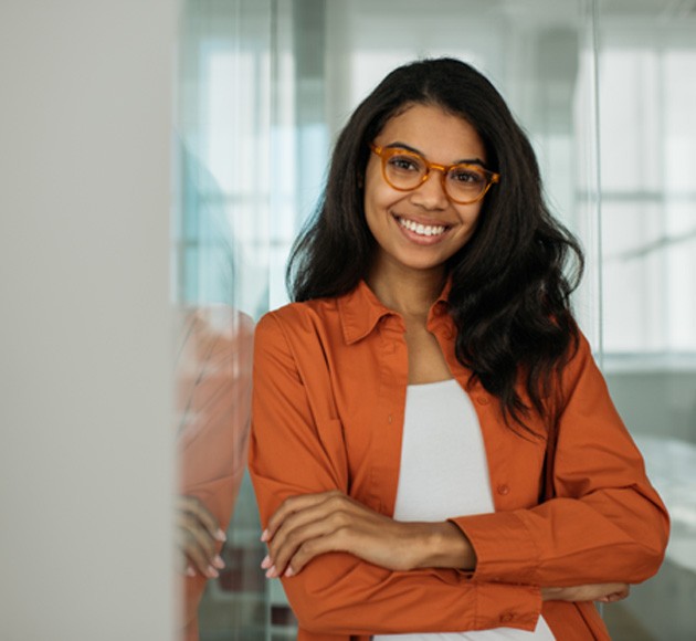 businesswoman standing against a glass wall