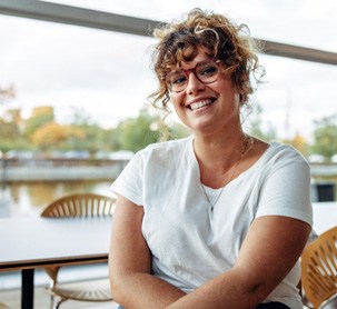 a smiling woman sitting in a cafe