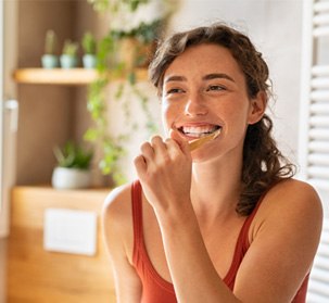 woman brushing her teeth in a bathroom