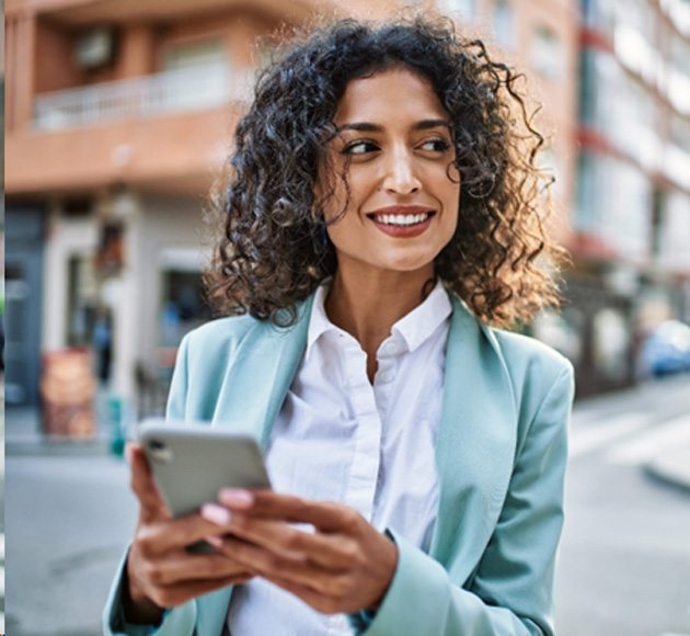 a smiling businesswoman looking at her cellphone 