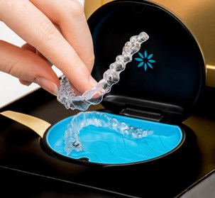 a person taking out a new set of aligners from a hard case